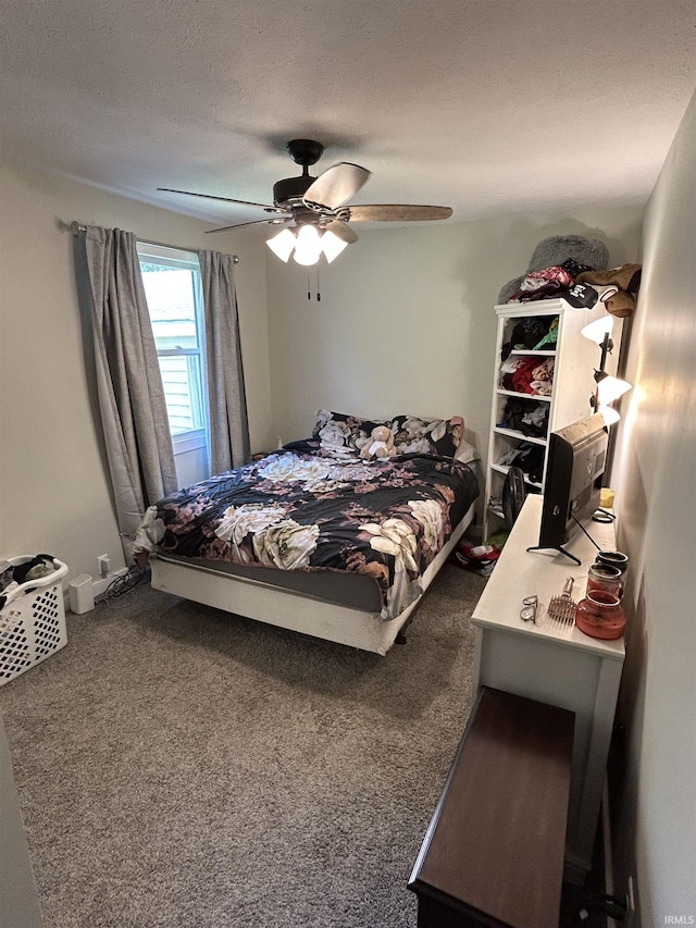 bedroom with ceiling fan, dark carpet, and a textured ceiling