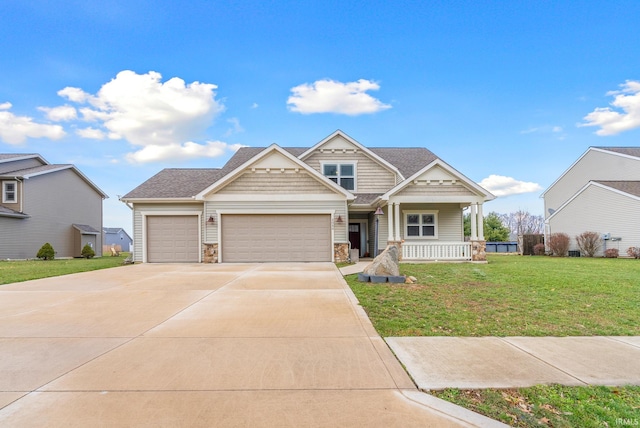 view of front of property featuring a porch, a garage, and a front yard