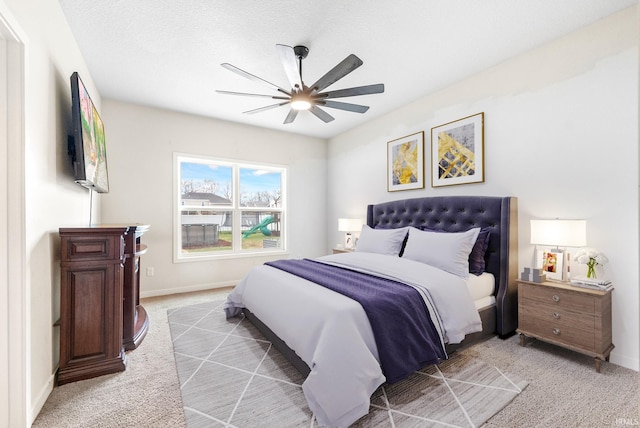 carpeted bedroom with ceiling fan and a textured ceiling