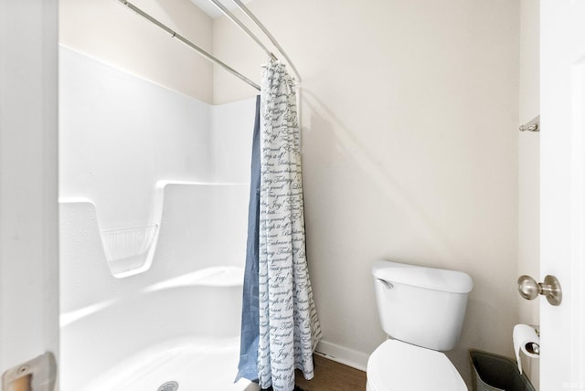 bathroom featuring hardwood / wood-style flooring, a shower with curtain, and toilet