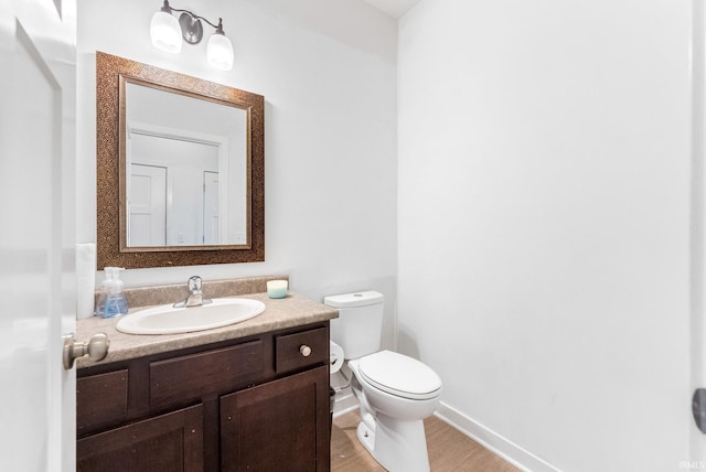 bathroom with vanity, wood-type flooring, and toilet