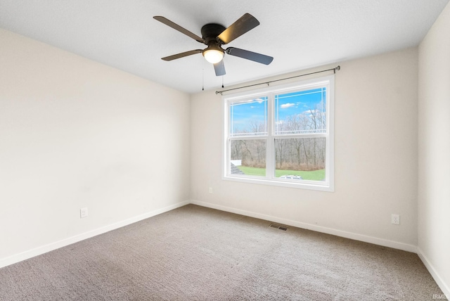 carpeted spare room featuring ceiling fan