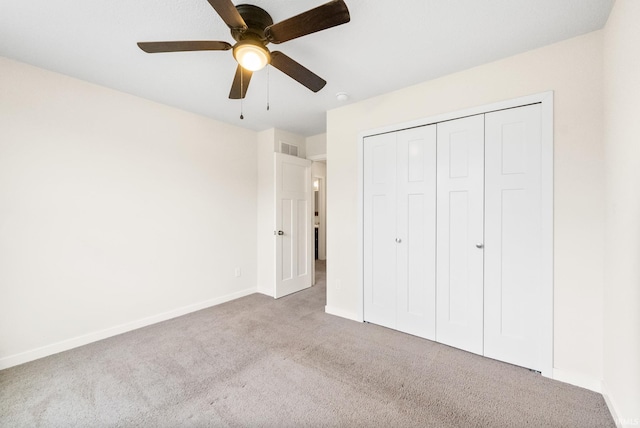 unfurnished bedroom with ceiling fan, light colored carpet, and a closet