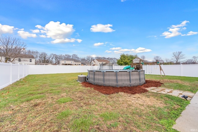 view of yard with a playground and a fenced in pool