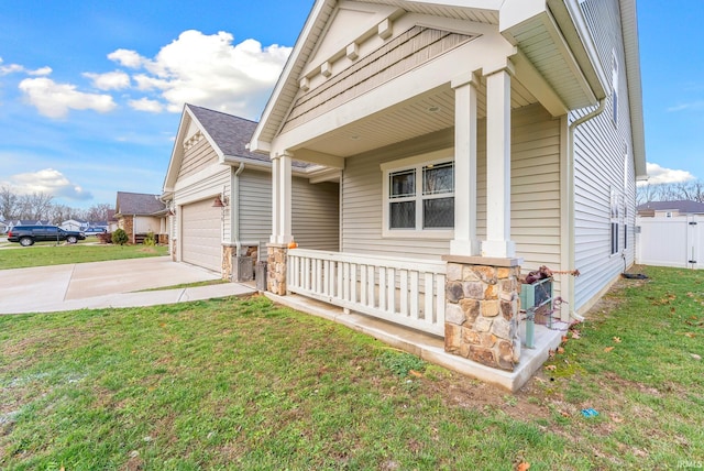 exterior space featuring a lawn, covered porch, and a garage