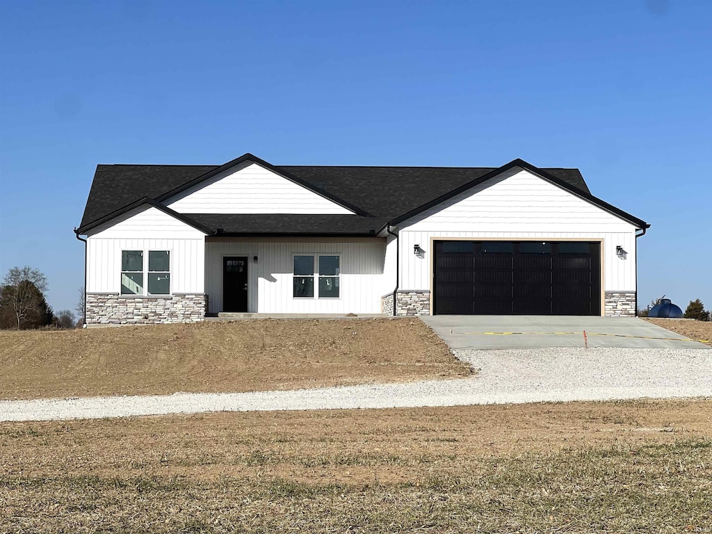 modern farmhouse featuring a garage and a front yard