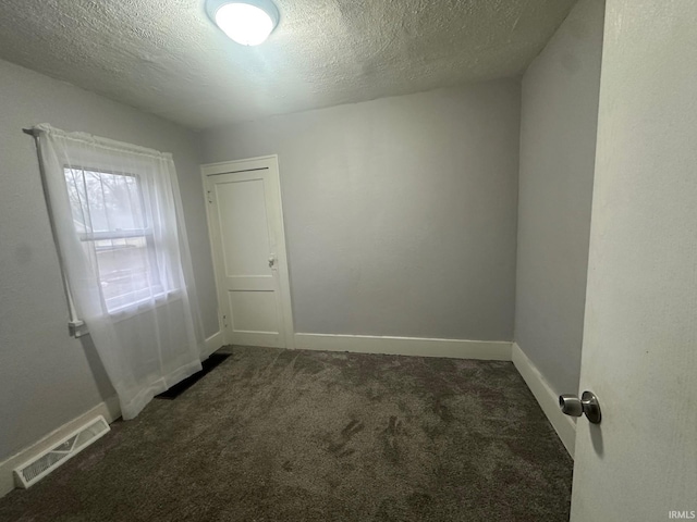 carpeted spare room with a textured ceiling