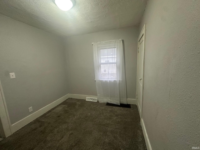 carpeted spare room featuring a textured ceiling