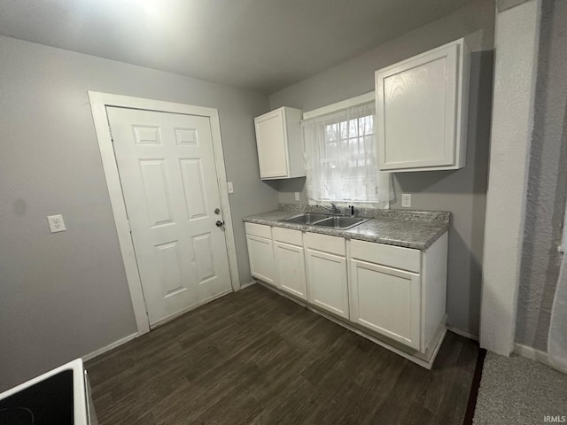 kitchen with dark hardwood / wood-style flooring, sink, and white cabinets