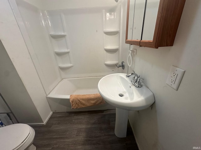 full bathroom with hardwood / wood-style flooring, sink, toilet, and shower / washtub combination