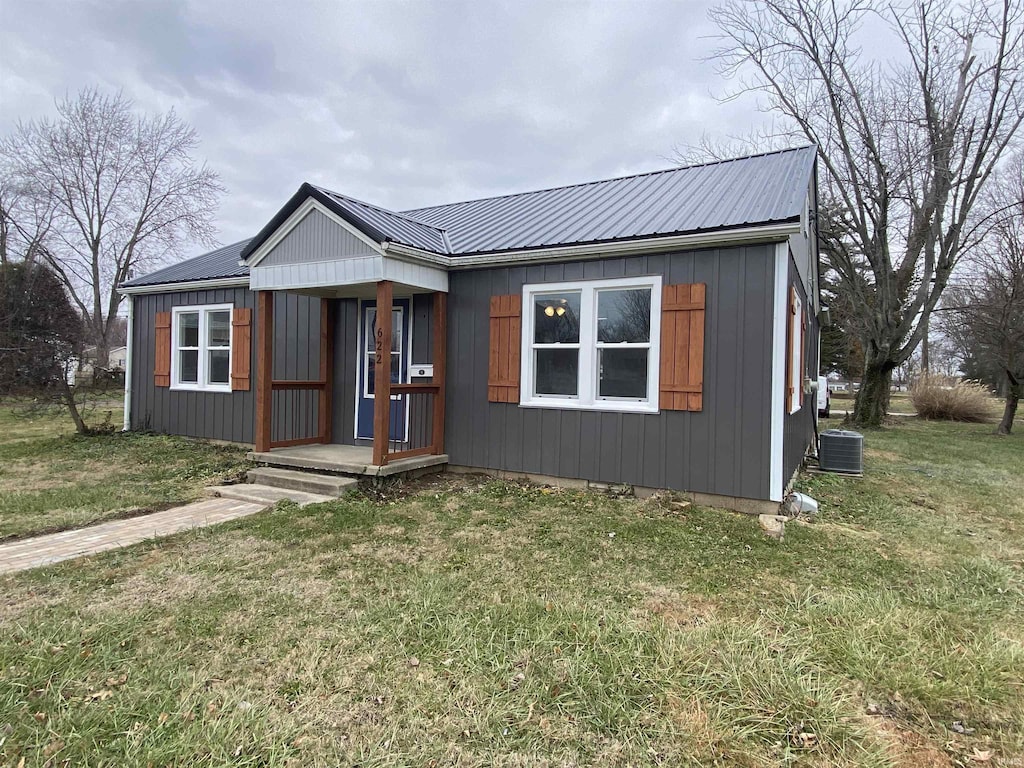 view of front of home with a front lawn and central air condition unit