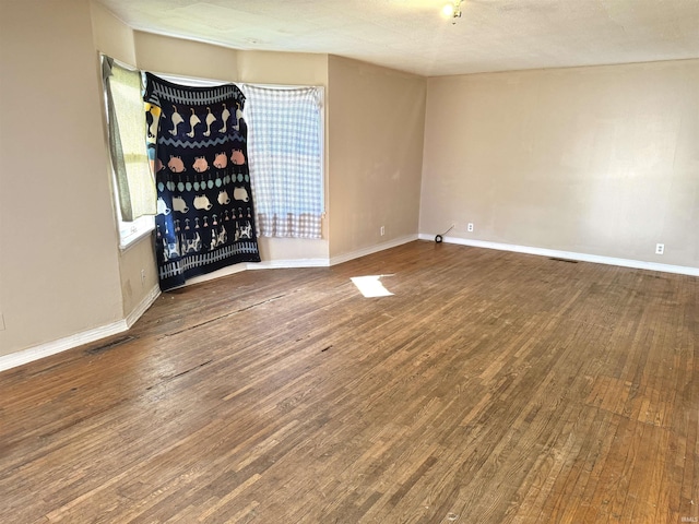 empty room featuring wood-type flooring and a textured ceiling