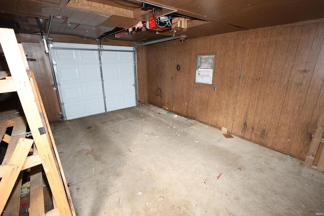 garage featuring wood walls and a garage door opener