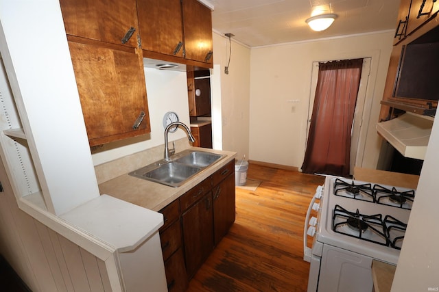 kitchen featuring dark hardwood / wood-style floors, white gas range, crown molding, and sink