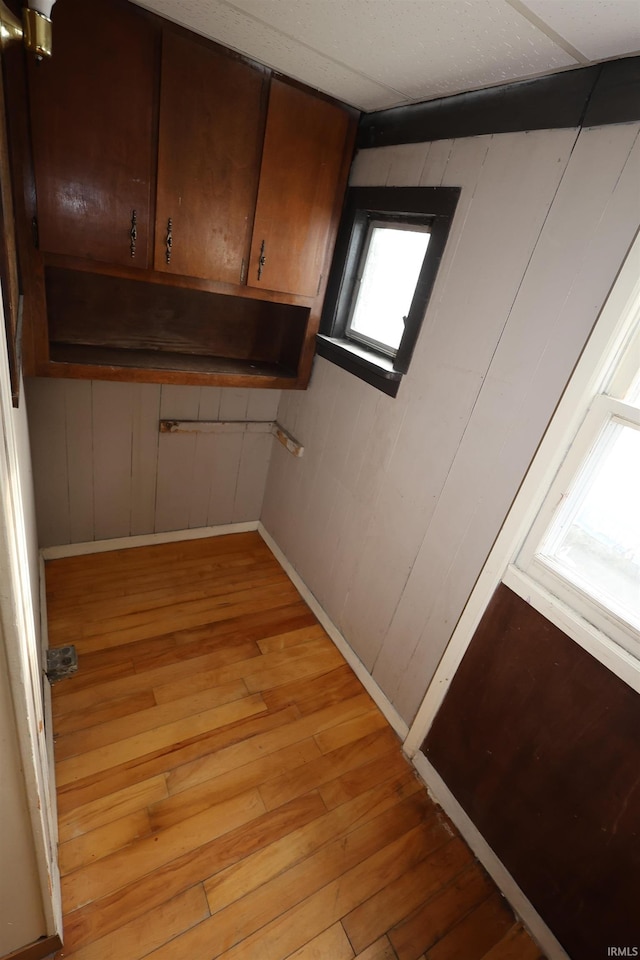 kitchen with wood walls and light wood-type flooring