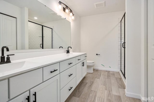 bathroom featuring walk in shower, vanity, toilet, and hardwood / wood-style floors