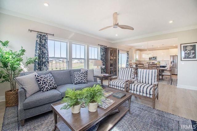 living room featuring ceiling fan, ornamental molding, and hardwood / wood-style floors