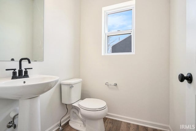 bathroom with toilet, sink, and hardwood / wood-style flooring