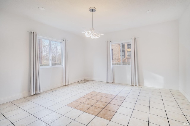 tiled empty room featuring a notable chandelier