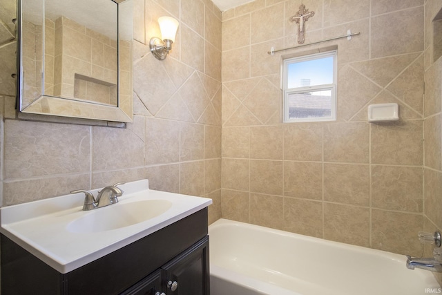 bathroom with vanity, tile walls, and tiled shower / bath combo