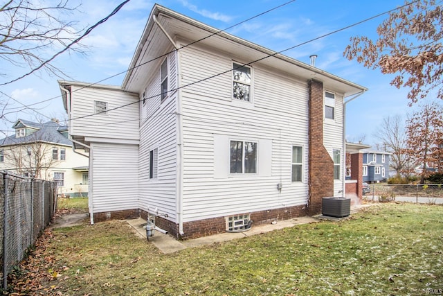 back of house featuring central AC unit and a yard