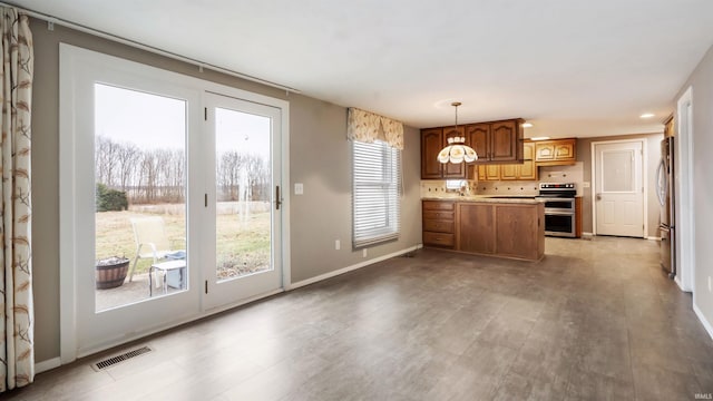 kitchen with pendant lighting, light wood-type flooring, and appliances with stainless steel finishes