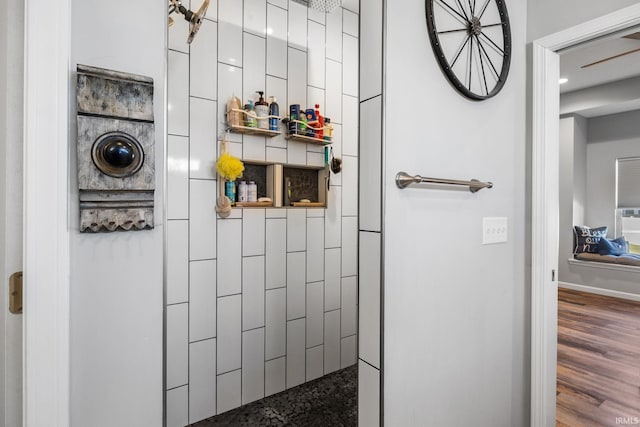 bathroom with tiled shower and hardwood / wood-style flooring