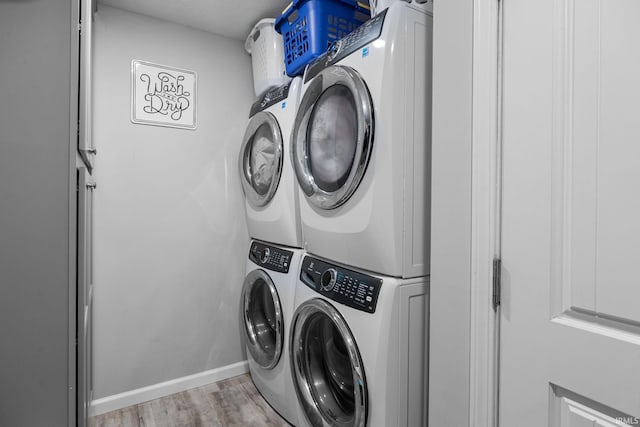 washroom featuring stacked washer / drying machine and light hardwood / wood-style floors