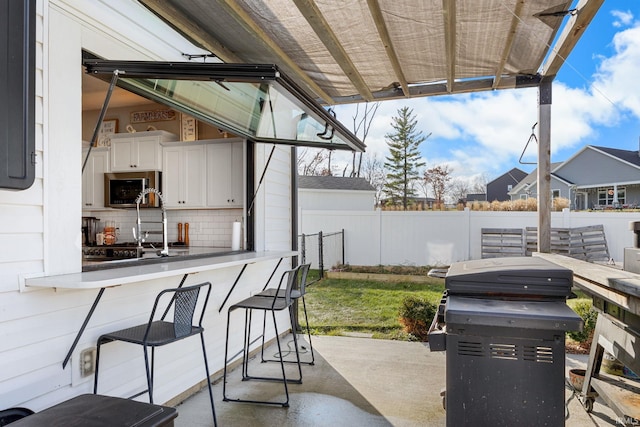 view of patio with a bar and grilling area