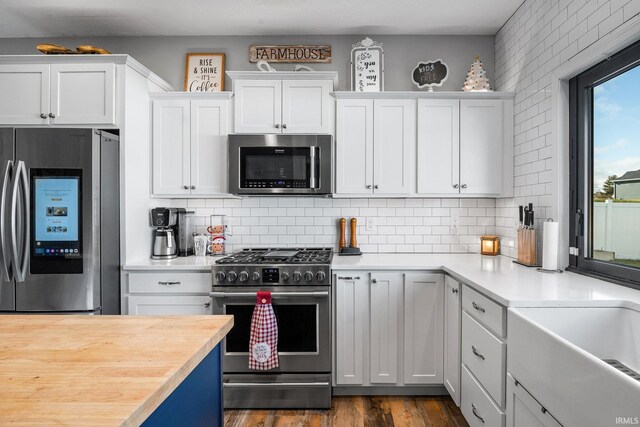 kitchen featuring backsplash, white cabinetry, dark hardwood / wood-style flooring, and stainless steel appliances