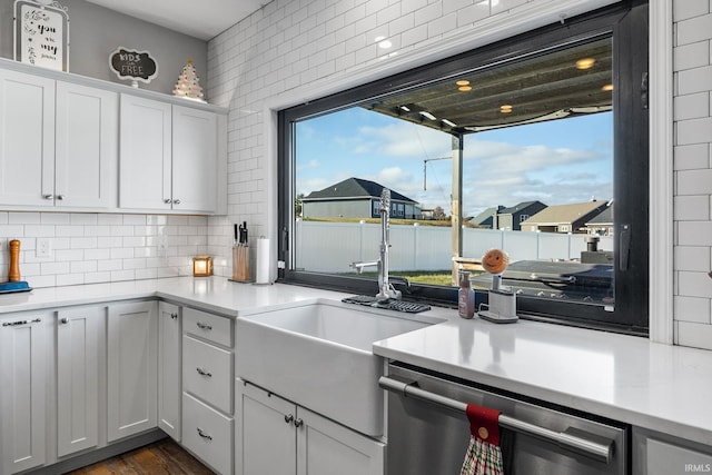 kitchen with backsplash, sink, dishwasher, dark hardwood / wood-style floors, and white cabinetry