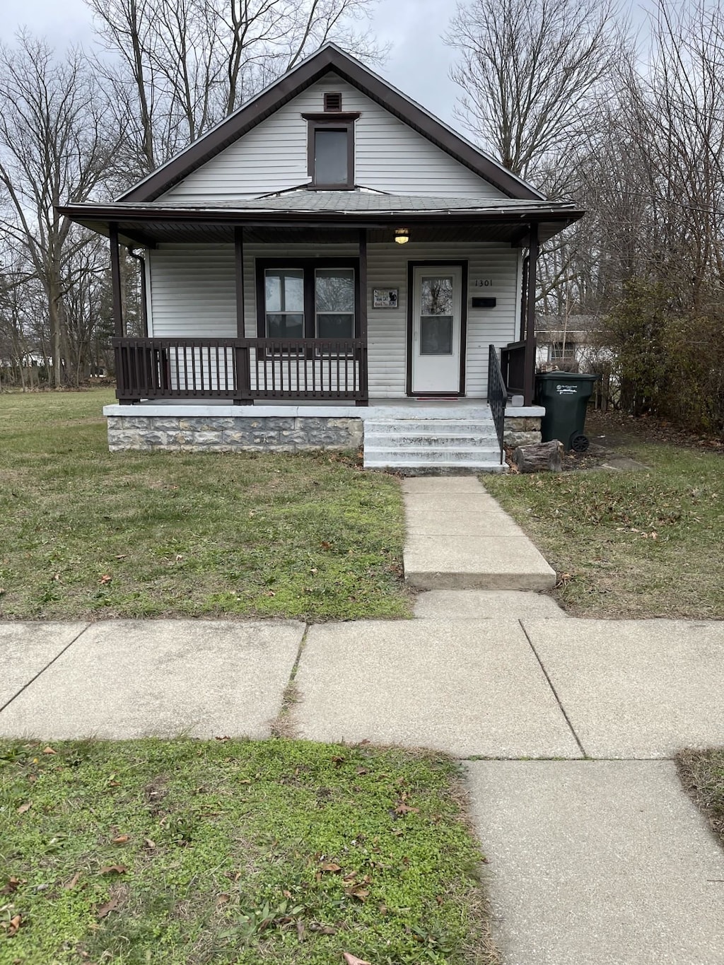 bungalow featuring a front lawn and a porch