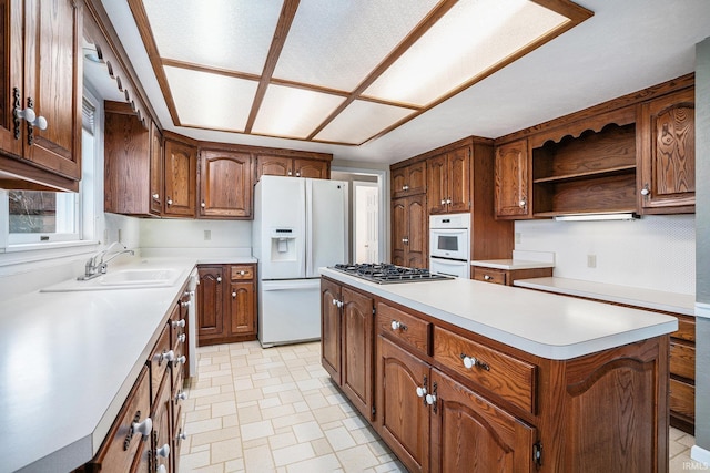 kitchen with sink, a center island, and white appliances