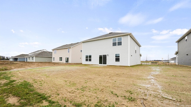 rear view of house featuring a yard