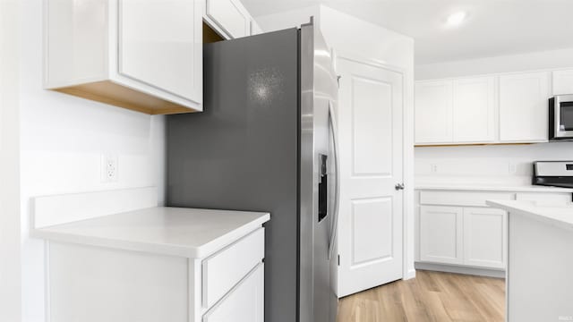 kitchen featuring white cabinetry, stainless steel appliances, and light hardwood / wood-style floors