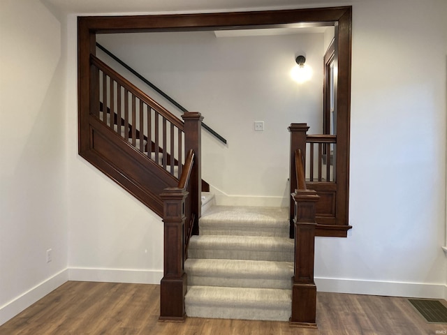 staircase with hardwood / wood-style floors