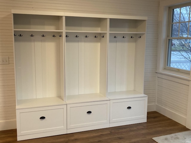 mudroom featuring dark wood-type flooring and wooden walls