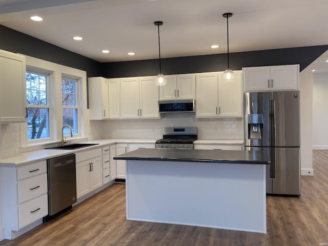 kitchen featuring pendant lighting, white cabinets, sink, and stainless steel appliances