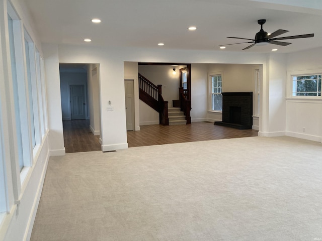 unfurnished living room with ceiling fan and carpet