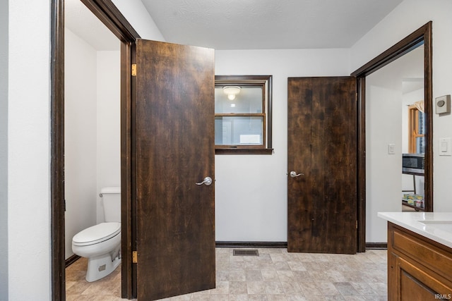 bathroom with vanity, a textured ceiling, and toilet