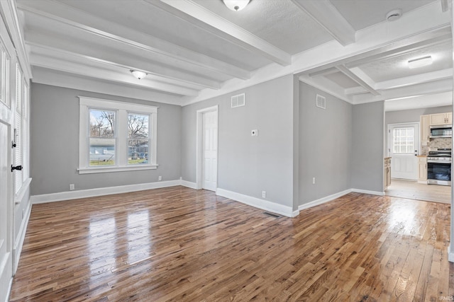 unfurnished living room with beamed ceiling and light hardwood / wood-style floors