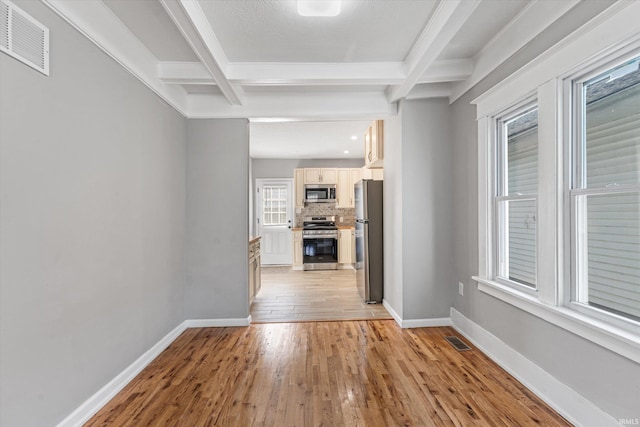 unfurnished living room with beamed ceiling and light hardwood / wood-style floors