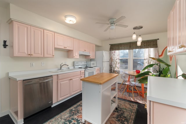 kitchen featuring a center island, white appliances, wooden counters, sink, and ceiling fan