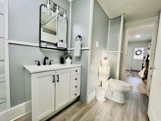 bathroom with hardwood / wood-style floors, vanity, and toilet