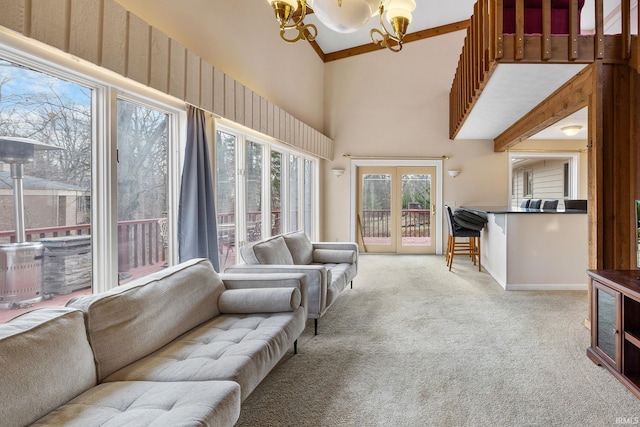 carpeted living room featuring high vaulted ceiling and a chandelier