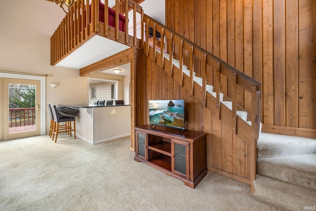 stairs featuring carpet flooring and wood walls