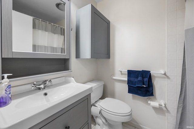 bathroom with tile patterned flooring, vanity, and toilet