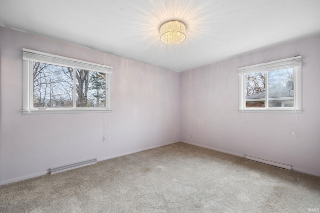 empty room with plenty of natural light, carpet floors, and a baseboard radiator