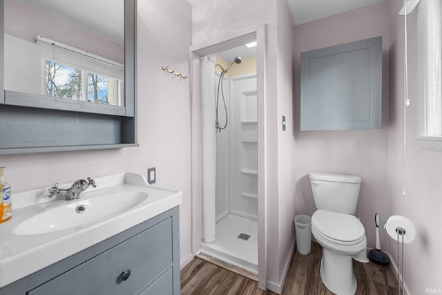 bathroom featuring hardwood / wood-style floors, vanity, toilet, and walk in shower