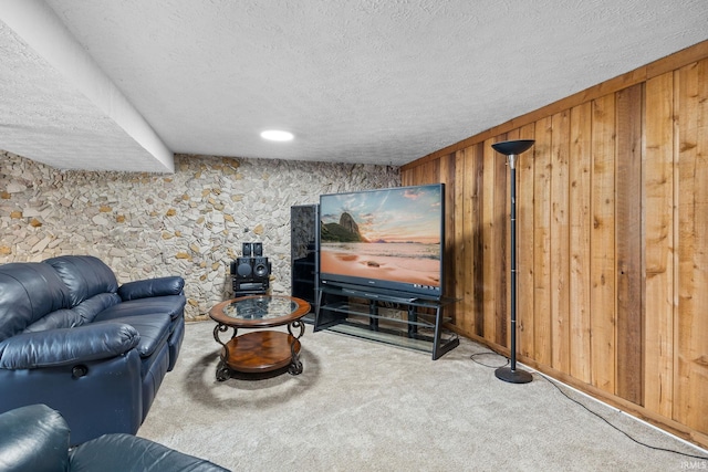 carpeted living room featuring a textured ceiling and wooden walls